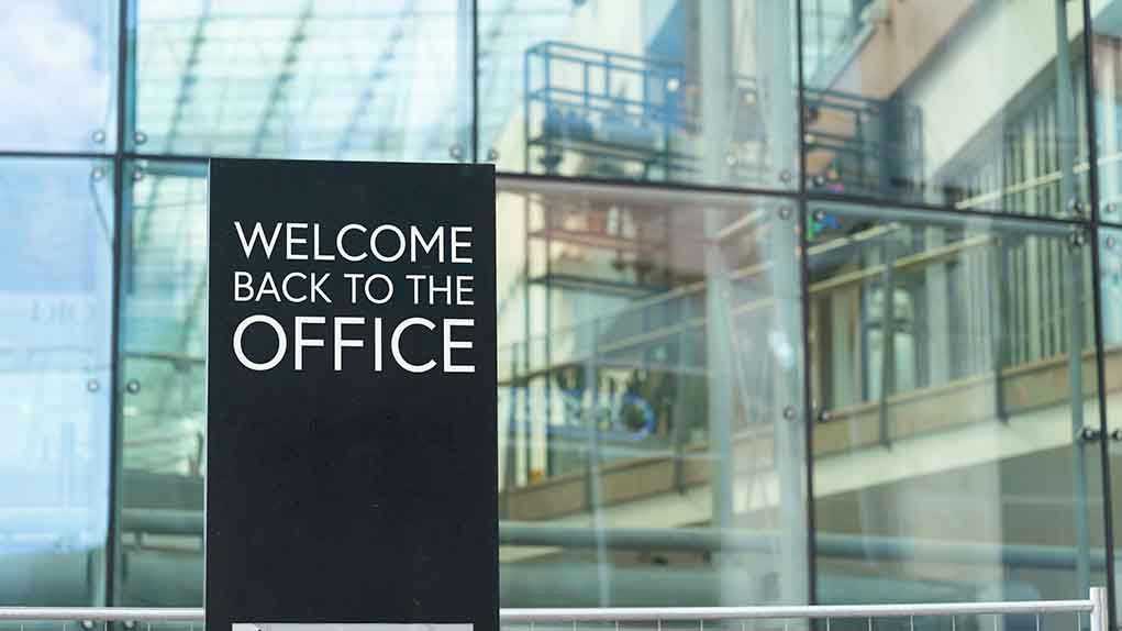 Welcome back to the office sign outside building.