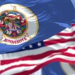 Omar’s Explosive Rant: Somali Voters Under Fire Minnesota state flag with American flag in background.