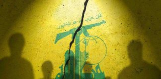Hezbollah flag with shadows of people and a crack.