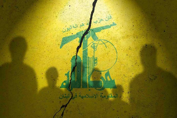 2373422413 Hezbollah flag with shadows of people and a crack.