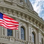 US flag in front of Capitol building.