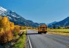 TERRIFYING Bus Crash Traps Teen Passengers A yellow school bus driving on a rural road surrounded by autumn trees and mountains