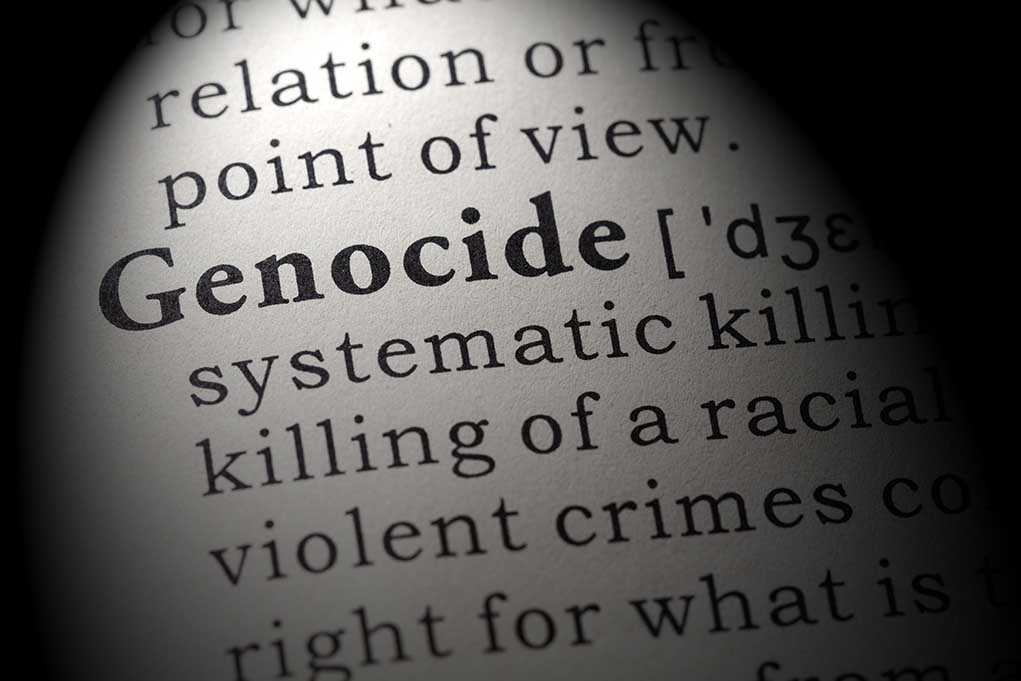 Close-up of the word Genocide in a dictionary with its definition