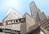 Wall Street Panic—Analyst Predicts AI Meltdown Street signs for Wall Street and Broad Street with skyscrapers in the background