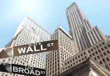 Wall Street Panic—Analyst Predicts AI Meltdown Street signs for Wall Street and Broad Street with skyscrapers in the background