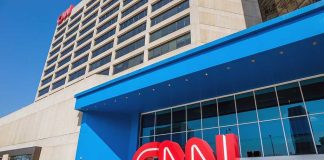 Exterior view of the CNN headquarters with a large red logo and blue entrance
