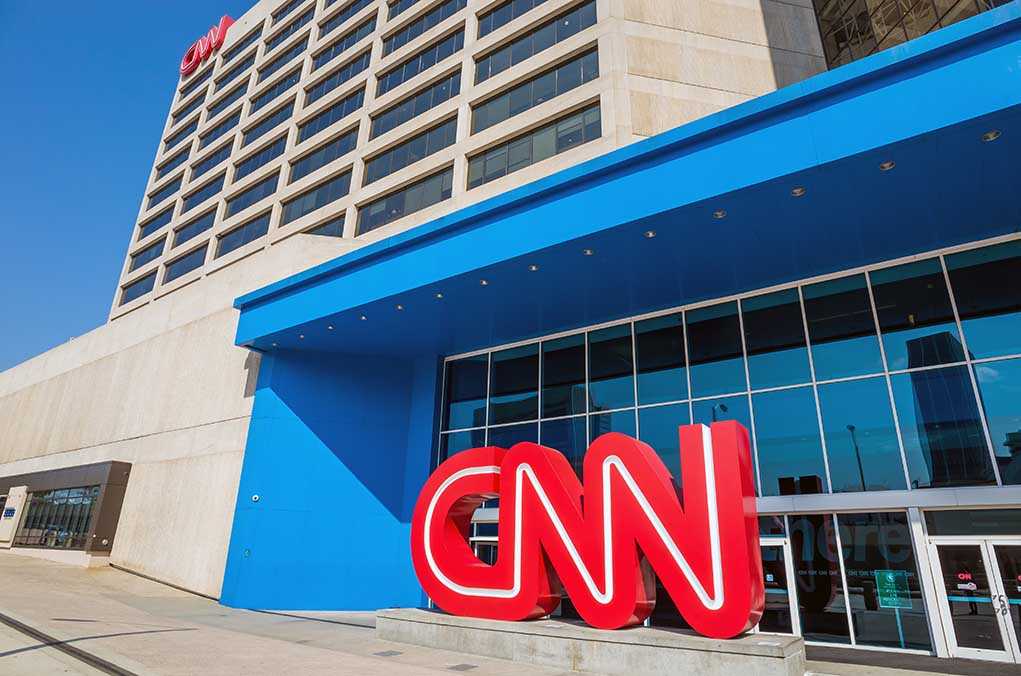 Exterior view of the CNN headquarters with a large red logo and blue entrance