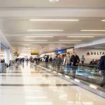 People walking through a busy airport terminal.