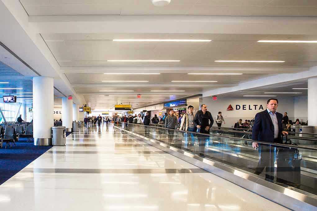 People walking through a busy airport terminal.