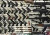 NRA War Chest Gutted Wall display with handguns and rifles for sale.