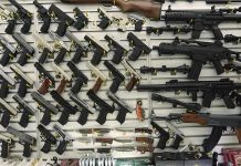 NRA War Chest Gutted Wall display with handguns and rifles for sale.