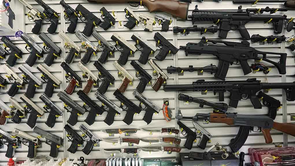 Wall display with handguns and rifles for sale.