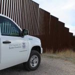 Campus Meltdown After Border Czar Erupts Border protection vehicle near a large metal fence.