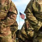 War Crime Allegations: U.S. Military Under Fire Soldiers stand in formation with American flag in background.