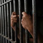 Chilling Baby Purchase Offer Rocks Auction Hands gripping prison cell bars tightly.