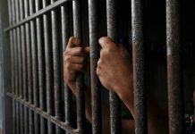 Chilling Baby Purchase Offer Rocks Auction Hands gripping prison cell bars tightly.