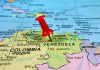 Venezuela’s Hidden Threat: Is WAR Imminent? Red pin on Venezuela, South America map.