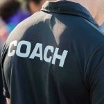 Person wearing a shirt labeled Coach.