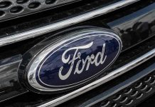 Ford CEO Panics Over Chinese EV Onslaught Ford logo on car grille close-up.