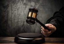 A judges gavel poised to strike a sound block