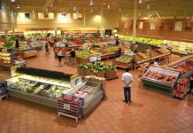 Interior of a grocery store filled with fresh produce and shoppers