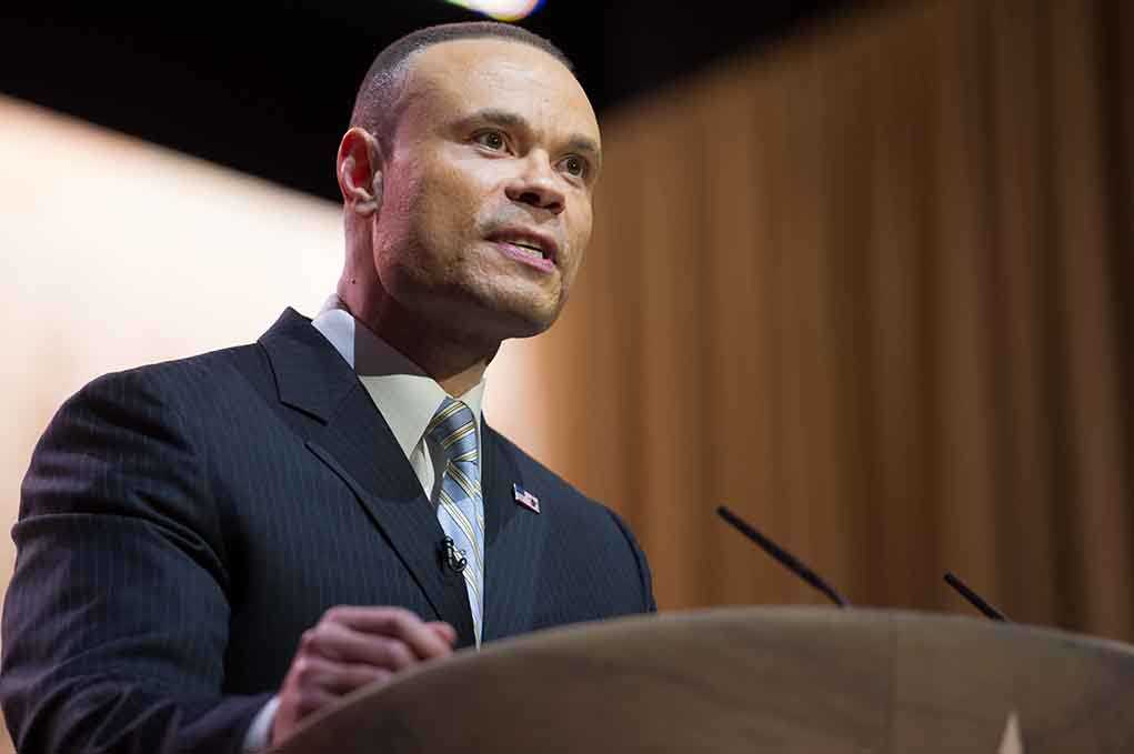 A man in a suit speaking at a podium during a conference
