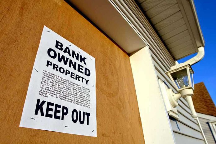 Sign on a boarded-up property indicating it is bank owned and warns to keep out