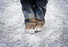 200,000 Child Deaths Loom—Who’s Responsible? A child standing barefoot on a gravel surface with dirty pants
