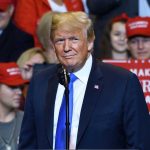 Ukraine War Plan Sits on Trump’s Desk Person at a rally with Make America Great Again signs.