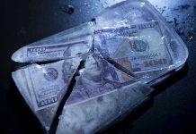 Hundred-dollar bills frozen in cracked ice block.