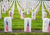 Rows of grave markers adorned with American flags in a military cemetery