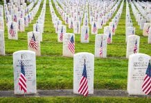 Veterans Worth MORE Dead Rows of grave markers adorned with American flags in a military cemetery