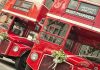 Two red double-decker buses decorated for a wedding with Just Married signs