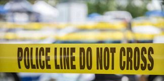 Yellow police line tape with Do Not Cross.