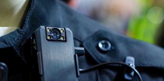 Cop Turned Insider—Gang Intel Shock Body camera attached to a black uniform.