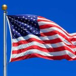 Waving American flag against a clear blue sky