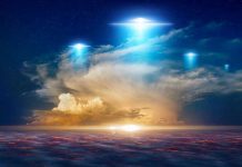 Glowing lights above dramatic sunset clouds.