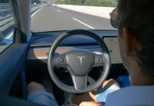 Man using autopilot mode in a Tesla car.