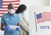 People voting with masks and gloves at polling station.