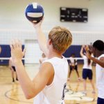 Schools Struggle as Trump’s Fitness Test Returns Players about to serve a volleyball in gym.