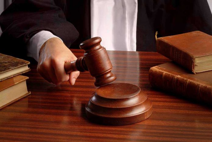 Judges gavel on desk with books.