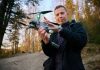 Person holding a drone in a forest.