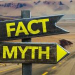 Directional signs labeled Fact and Myth in desert.