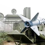 Navy’s SPY-6 Radar: Unseen Power Unleashed Military missile launcher with radar systems in a foggy field.