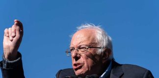Bernie Sanders’ Hypocrisy! Luxurious Spending Revealed A speaker passionately addressing a crowd at an outdoor rally