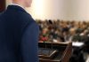 A speaker at a podium addressing an audience