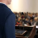 Outrage Erupts: Texas Campaign Descends Into Chaos A speaker at a podium addressing an audience