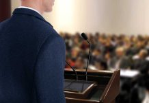 A speaker at a podium addressing an audience