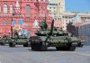 Military tanks on parade in Red Square with historical buildings in the background