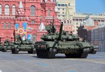 Military tanks on parade in Red Square with historical buildings in the background